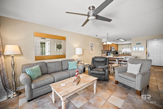 living area with light tile patterned flooring, a textured ceiling, and a ceiling fan