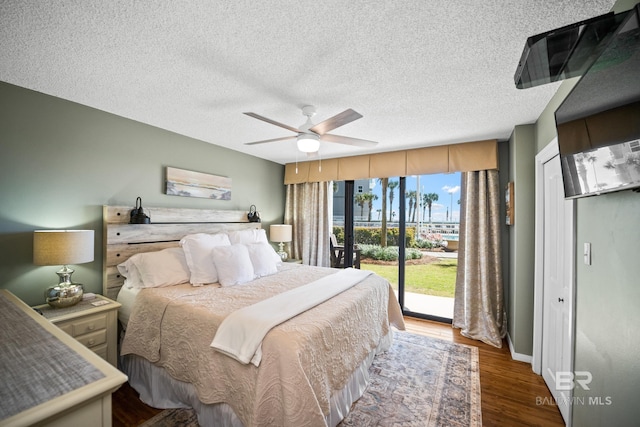 bedroom featuring a ceiling fan, access to exterior, wood finished floors, and a textured ceiling