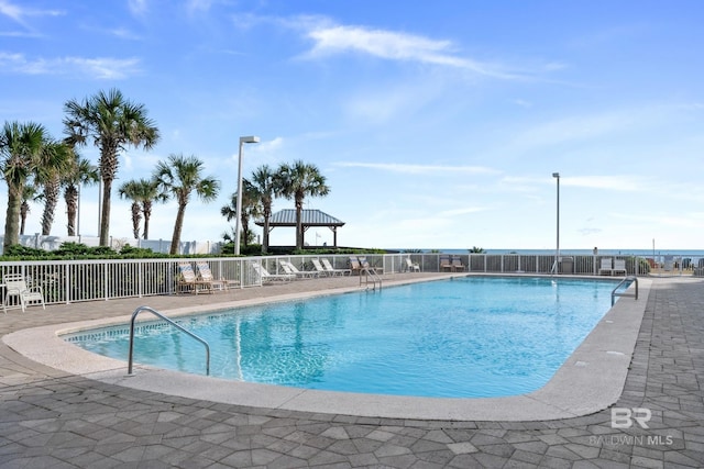 pool with a patio and fence