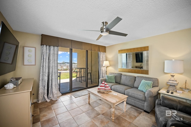 living room featuring tile patterned floors, a textured ceiling, and ceiling fan