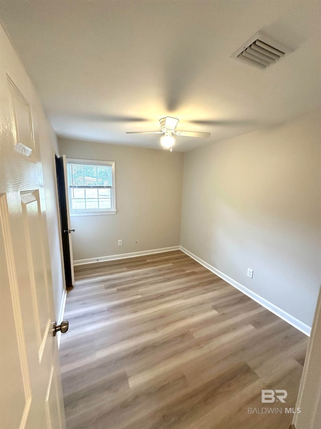 spare room with ceiling fan and light wood-type flooring