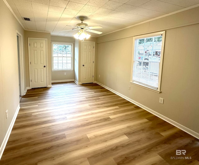 unfurnished bedroom featuring ceiling fan, wood-type flooring, and crown molding