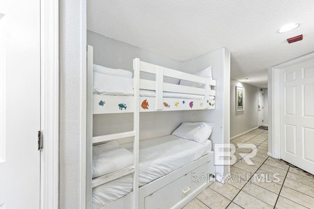 bedroom with light tile patterned flooring and a textured ceiling