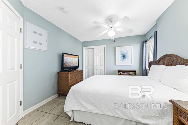 tiled bedroom featuring ceiling fan and a closet