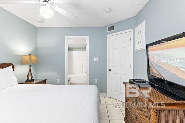 bedroom with ceiling fan, a closet, light tile patterned floors, and a textured ceiling