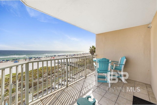 balcony with a water view and a view of the beach