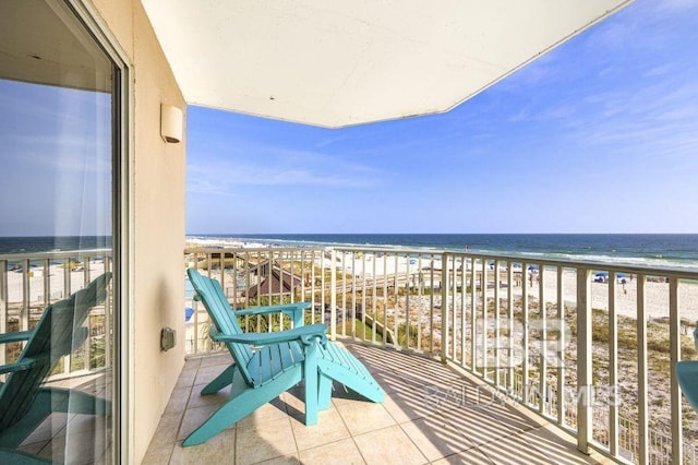 balcony featuring a view of the beach and a water view