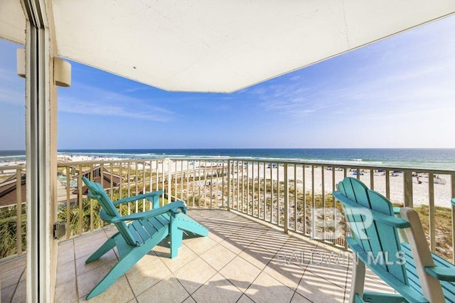 balcony with a water view and a view of the beach