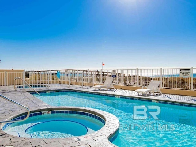 view of swimming pool with a hot tub