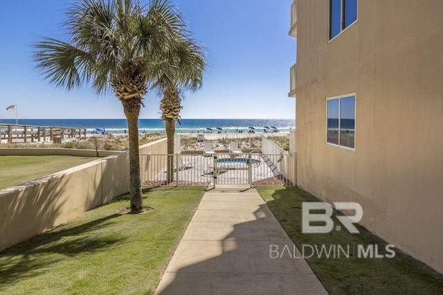 view of yard featuring a water view and a beach view