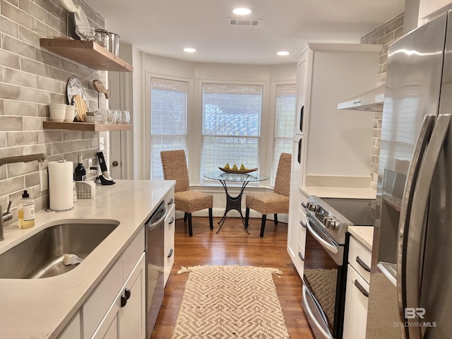 18175 Scenic Highway 98 Unit 12, Fairhope, AL 36532 - kitchen with appliances with stainless steel finishes, open shelves, wood finished floors, under cabinet range hood, and white cabinets