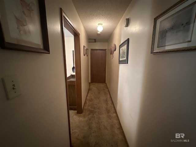 hallway featuring carpet floors and a textured ceiling