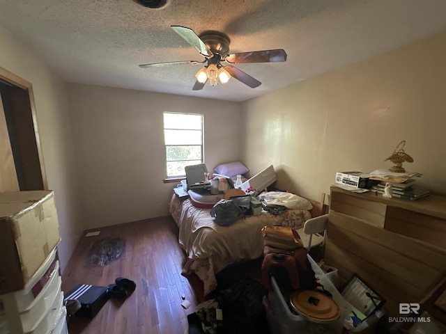 bedroom featuring ceiling fan, wood-type flooring, and a textured ceiling