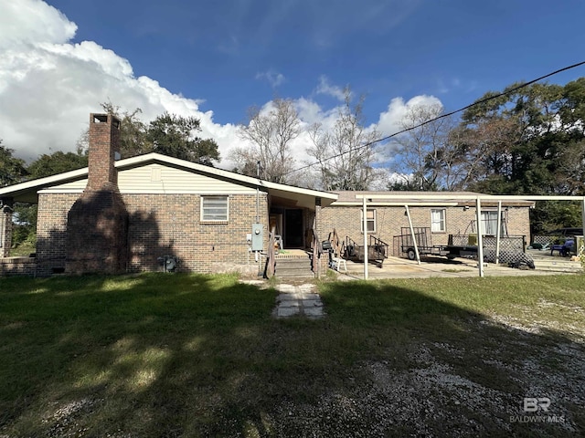 back of house with a lawn and a patio