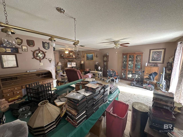 dining space with ceiling fan, a textured ceiling, and a brick fireplace