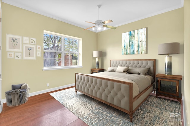 bedroom featuring crown molding, baseboards, ceiling fan, and wood finished floors