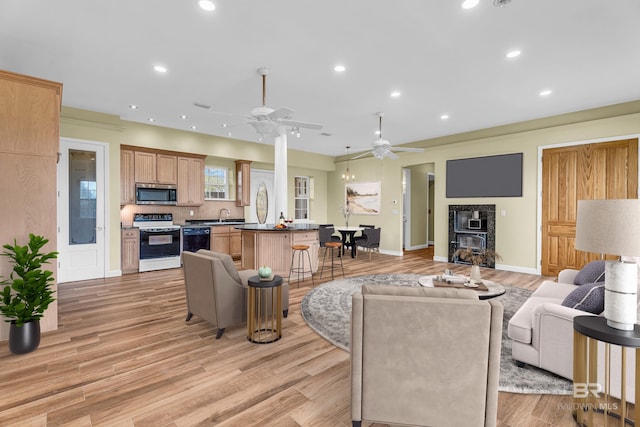living area with ceiling fan, light wood-type flooring, recessed lighting, and baseboards