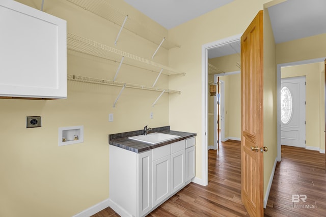 laundry area with electric dryer hookup, wood finished floors, washer hookup, a sink, and cabinet space