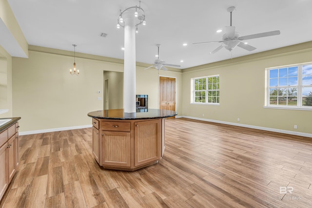 kitchen with ceiling fan with notable chandelier, light wood-style flooring, visible vents, open floor plan, and baseboards