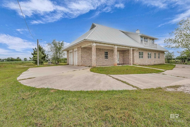 view of property exterior with concrete driveway, a balcony, an attached garage, a yard, and metal roof