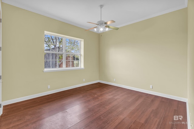 spare room with dark wood-style flooring, ceiling fan, ornamental molding, and baseboards