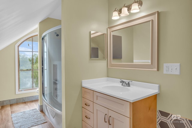 bathroom with shower / bath combination with glass door, vanity, wood finished floors, and lofted ceiling