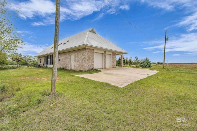 rear view of house with a garage, driveway, and a lawn