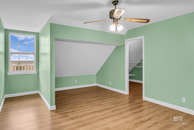 additional living space with baseboards, a ceiling fan, wood finished floors, and lofted ceiling