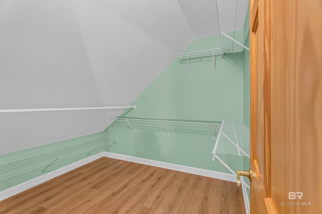 walk in closet with wood finished floors and lofted ceiling