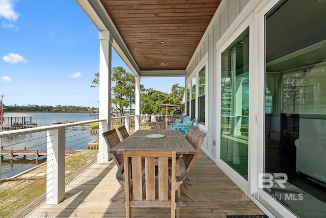 balcony featuring outdoor dining area and a water view