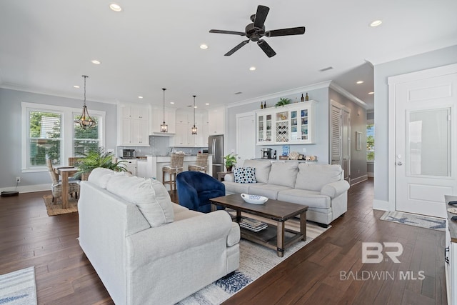 living room featuring baseboards, ornamental molding, recessed lighting, and ceiling fan