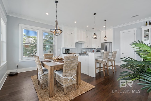 dining room with crown molding, dark wood finished floors, recessed lighting, and a notable chandelier