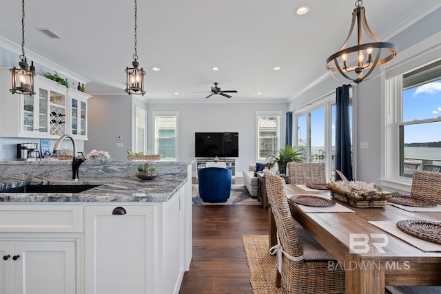 kitchen with visible vents, a sink, crown molding, and a wealth of natural light