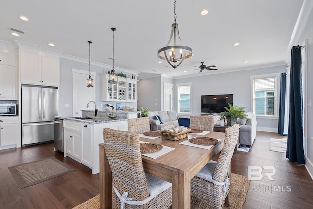 dining space with crown molding, dark wood-style flooring, and a wealth of natural light