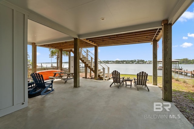 view of patio / terrace featuring a water view and stairs