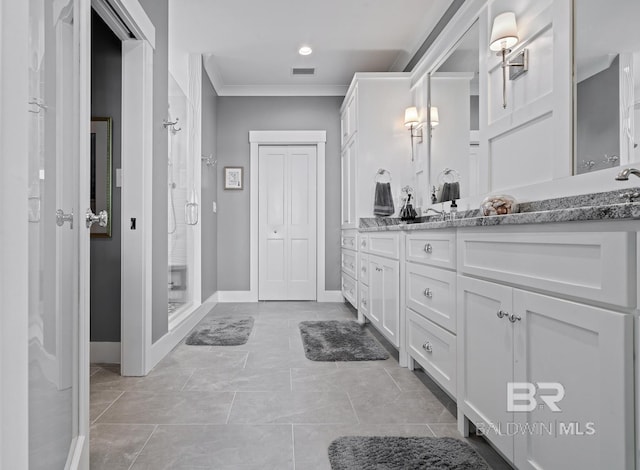 bathroom with visible vents, double vanity, ornamental molding, baseboards, and a shower stall
