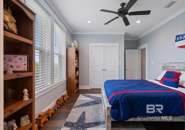 bedroom featuring crown molding, ceiling fan, dark wood-type flooring, visible vents, and a closet
