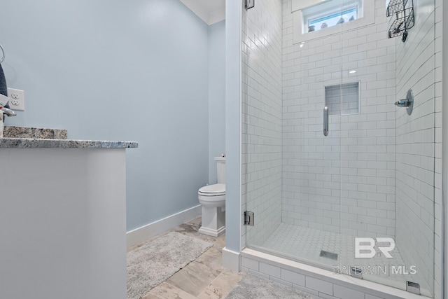 bathroom with baseboards, marble finish floor, a stall shower, and toilet