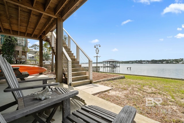 view of patio with a water view and stairway