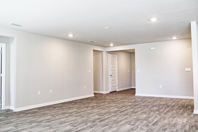 spare room featuring recessed lighting, wood finished floors, visible vents, and baseboards