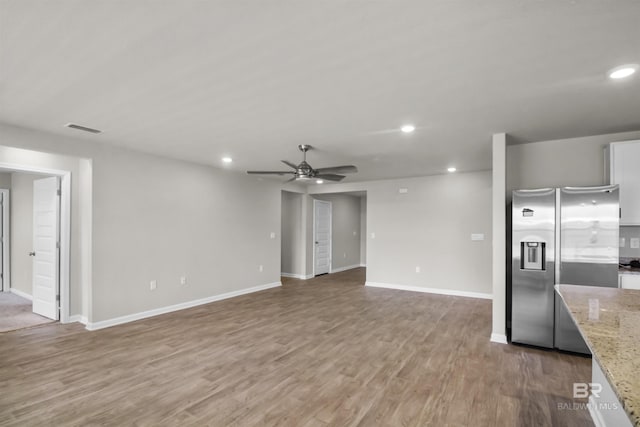 unfurnished living room featuring ceiling fan, baseboards, light wood finished floors, and recessed lighting