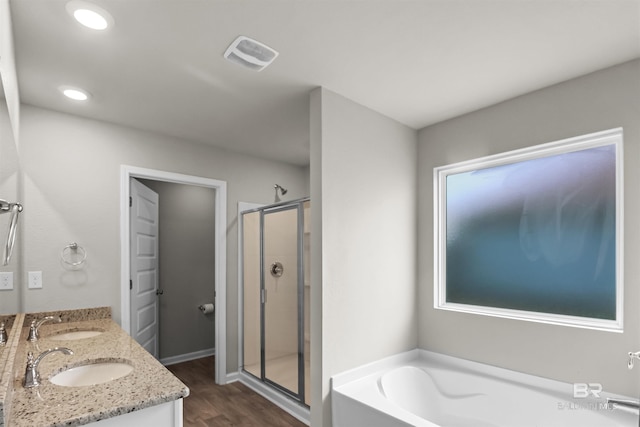bathroom featuring a sink, visible vents, wood finished floors, a shower stall, and a garden tub