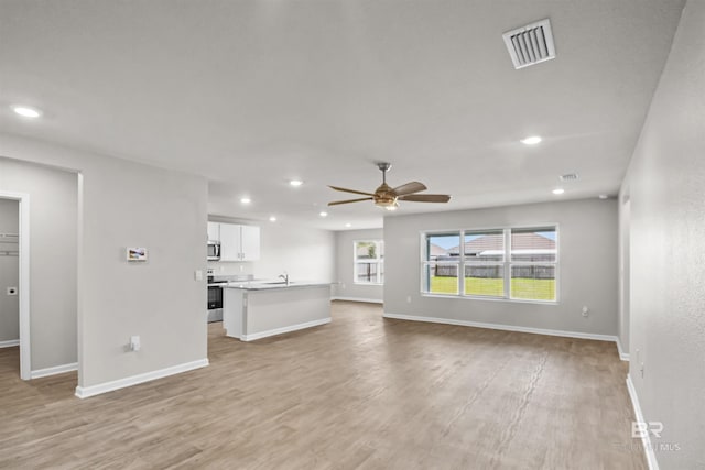 unfurnished living room featuring baseboards, visible vents, recessed lighting, light wood-style floors, and a ceiling fan