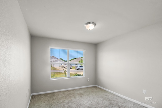 carpeted empty room with baseboards