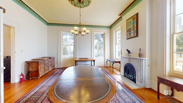 dining area with hardwood / wood-style floors, a wealth of natural light, and crown molding