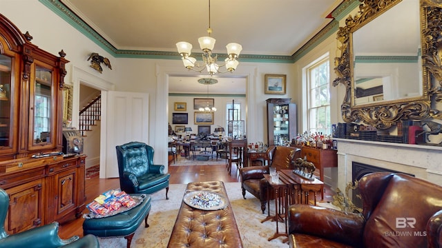 living room with crown molding, hardwood / wood-style flooring, and an inviting chandelier