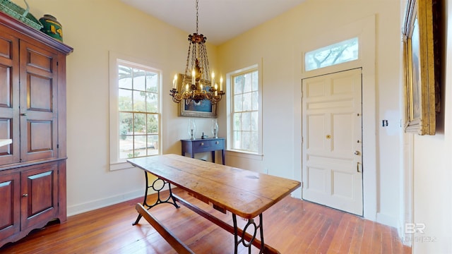 dining area featuring wood-type flooring, a chandelier, and a wealth of natural light