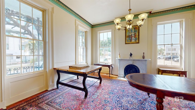 interior space featuring ornamental molding, an inviting chandelier, and wood-type flooring