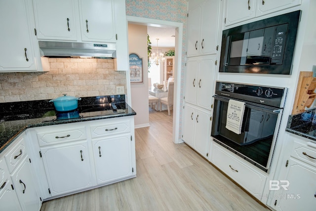 kitchen featuring black appliances, white cabinets, light wood-type flooring, and dark stone counters