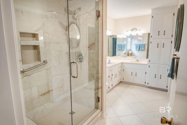 bathroom featuring a shower with door, vanity, and tile patterned flooring